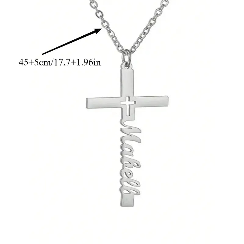Silver cross-shaped necklace with 'Mabell' engraving on a white background. Arrow points to chain and says 17.7 inches + 1.96 inches.